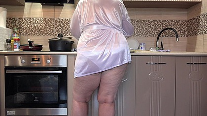 A plump wife prepares breakfast, while a home camera watches. A big ass in white panties under a short robe. PAWG.