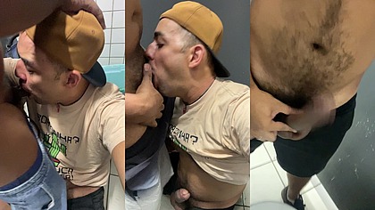 De joelhos chupando a rola de dois negros no box do banheiro da estacao.